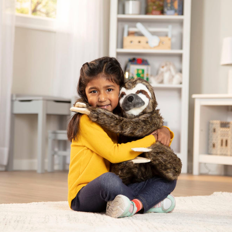 A kid playing with the Melissa & Doug Lifelike Plush Sloth Stuffed Animal (12W x 14.5H x 9D in)