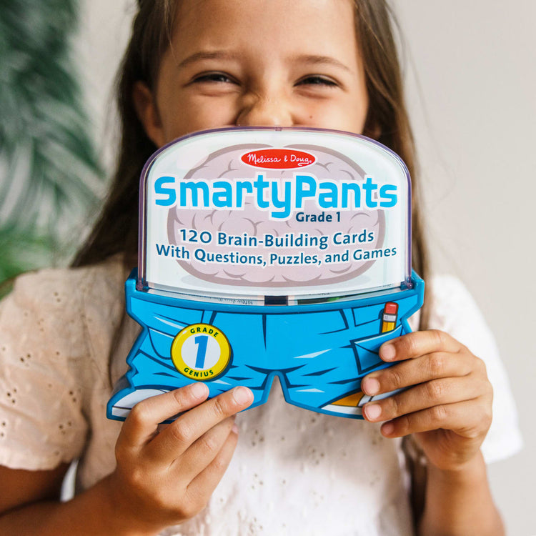 A kid playing with the Melissa & Doug Smarty Pants 1st Grade Card Set - 120 Educational, Brain-Building Questions, Puzzles, and Games
