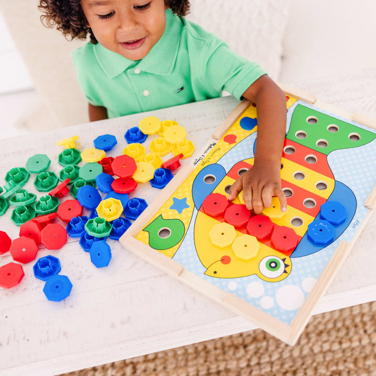 A kid playing with the Melissa & Doug Sort and Snap Color Match - Sorting and Patterns Educational Toy