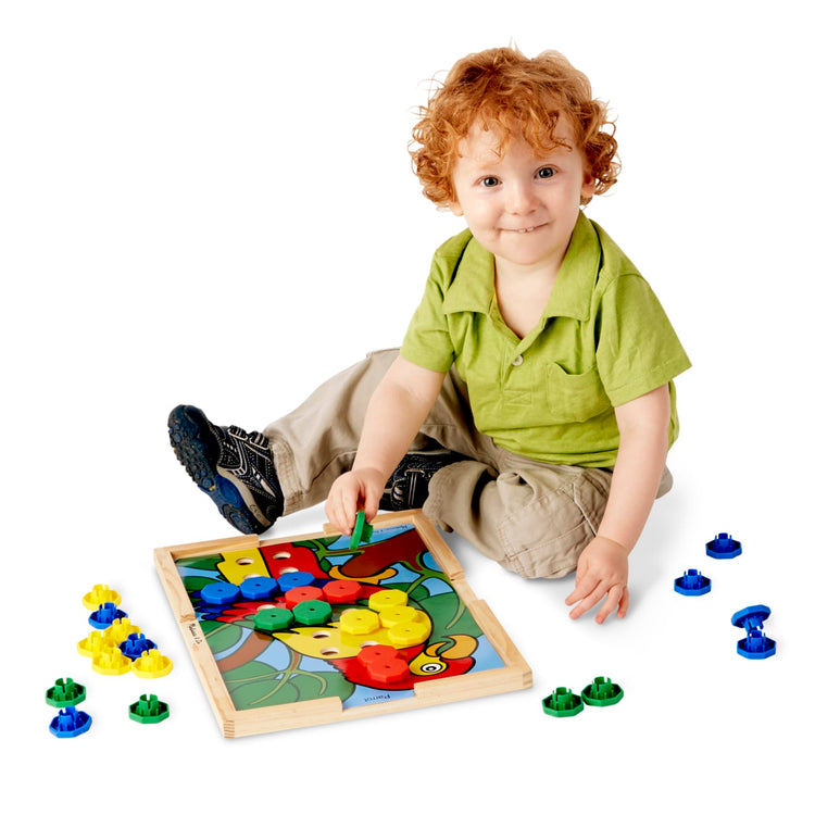 A child on white background with the Melissa & Doug Sort and Snap Color Match - Sorting and Patterns Educational Toy