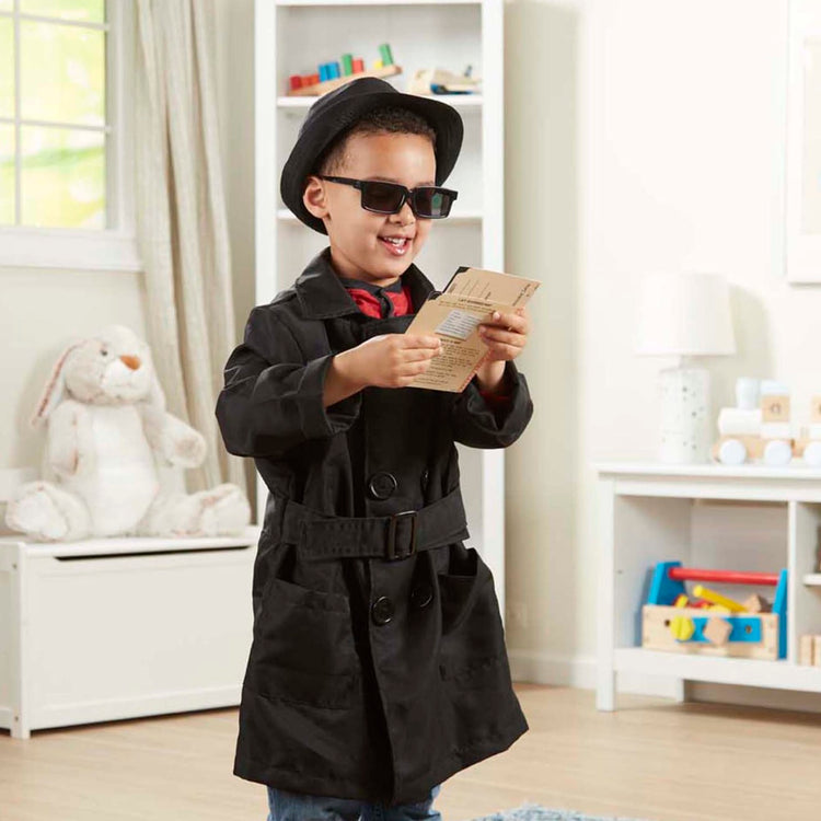 A kid playing with the Melissa & Doug Spy Costume Role Play Set