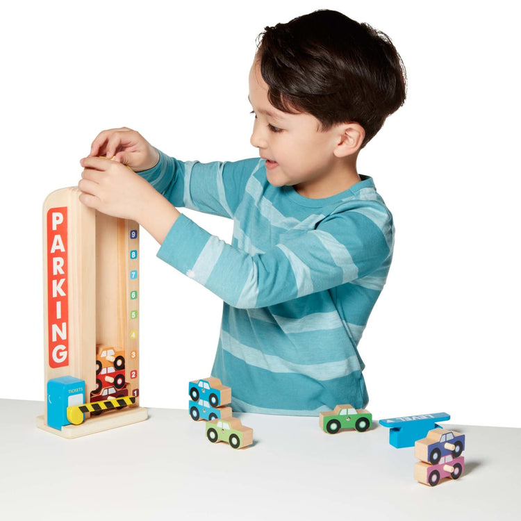 A child on white background with the Melissa & Doug Stack & Count Wooden Parking Garage With 10 Cars