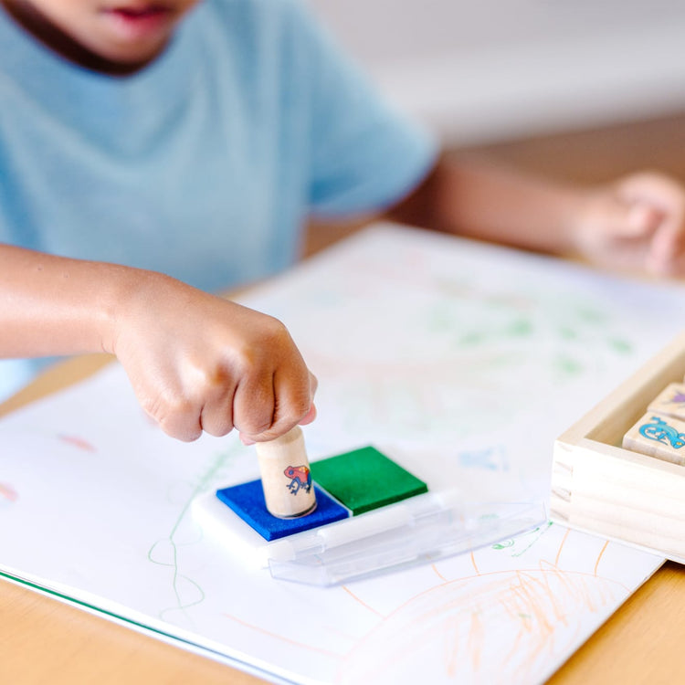 The front of the box for the Melissa & Doug Stamp-a-Scene Stamp Set: Rain Forest - 20 Wooden Stamps, 5 Colored Pencils, and 2-Color Stamp Pad