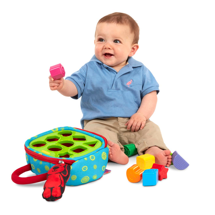A child on white background with the Melissa & Doug K's Kids Take-Along Shape Sorter Baby Toy With 2-Sided Activity Bag and 9 Textured Shape Blocks