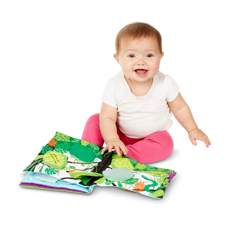 A child on white background with the Melissa & Doug Soft Activity Baby Book - The Wonderful World of Peekaboo!