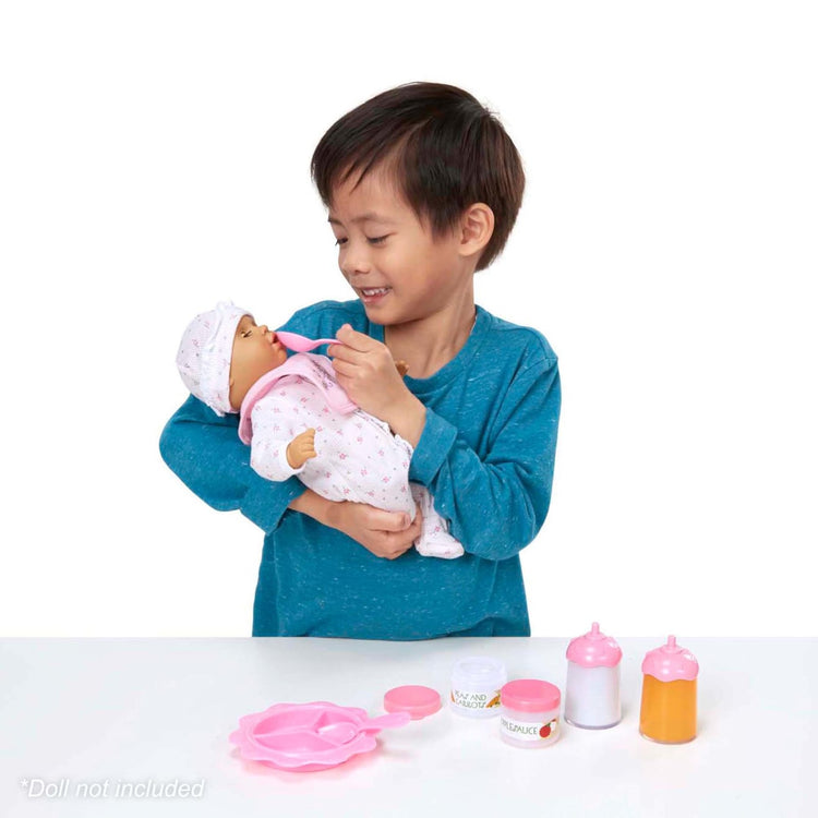 A child on white background with the Melissa & Doug Mine to Love Baby Food & Bottle Play Set