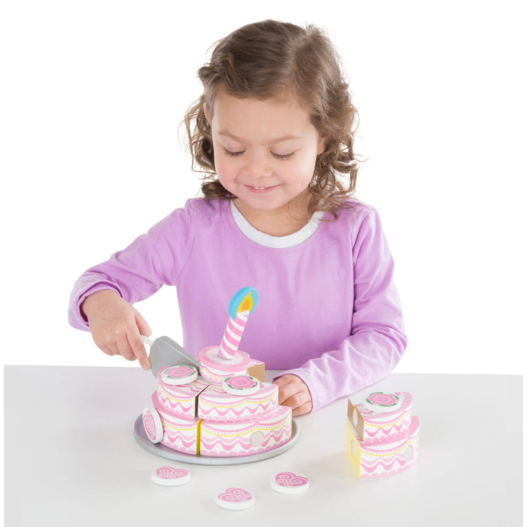 A child on white background with the Melissa & Doug Triple-Layer Party Cake Wooden Play Food Set