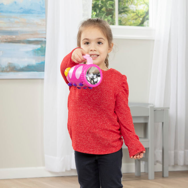 A kid playing with the Melissa & Doug Sunny Patch Trixie Ladybug Flashlight With Easy-Grip Handle