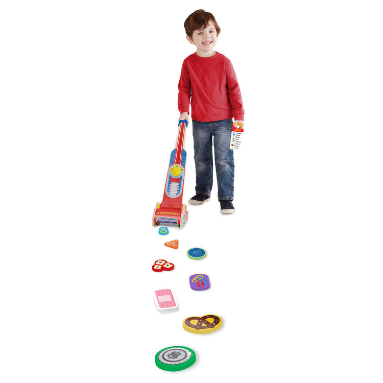 A child on white background with the Melissa & Doug Wooden Vacuum Cleaner Play Set (10 pcs)