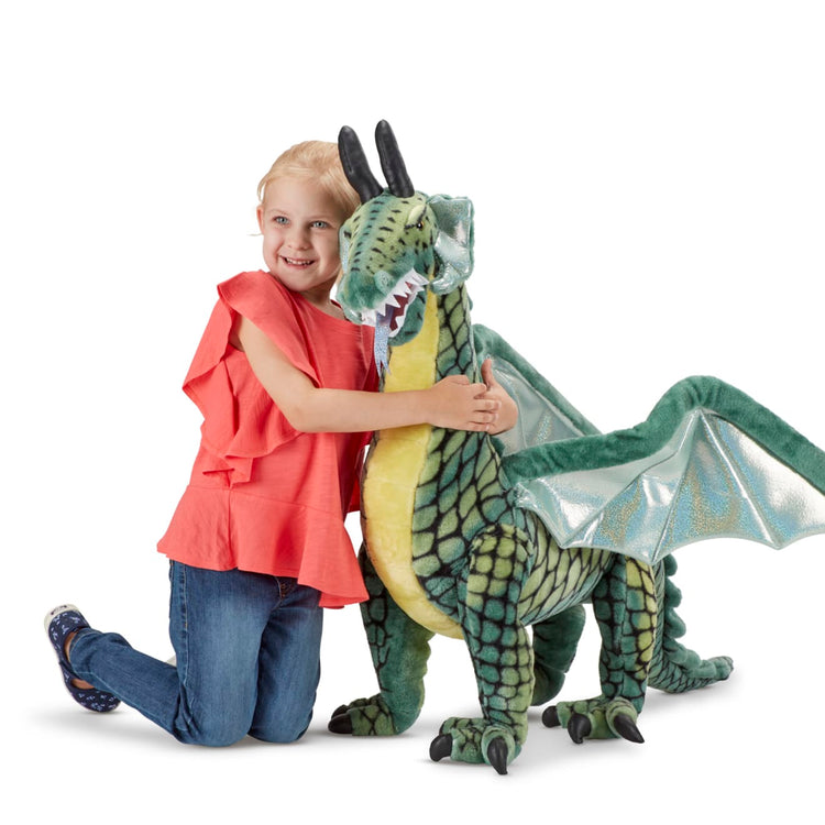 A child on white background with the Melissa & Doug Lifelike Plush Giant Winged Dragon Stuffed Animal (36 x 40.5 x 16 in)