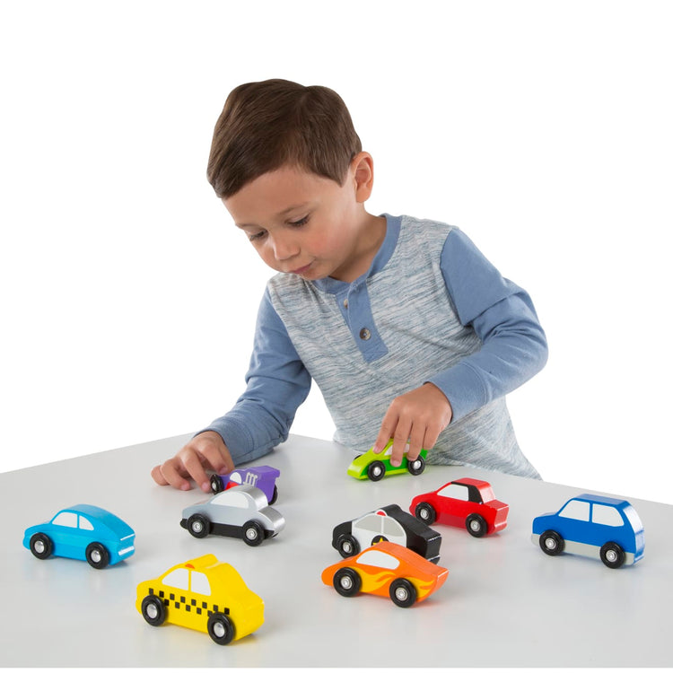 A child on white background with the Melissa & Doug Wooden Cars Vehicle Set in Wooden Tray