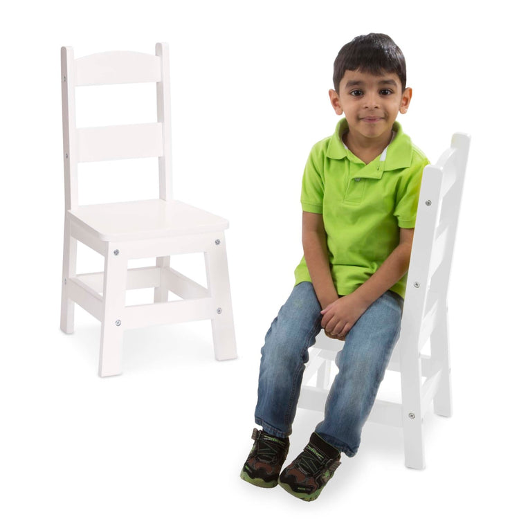 A child on white background with the Melissa & Doug Wooden Chair Pair [Natural, White, Espresso Brown]