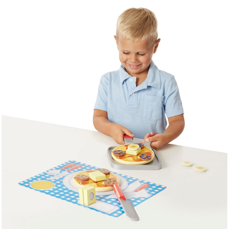 A child on white background with the Melissa & Doug Flip and Serve Pancake Set (19 pcs) - Wooden Breakfast Play Food