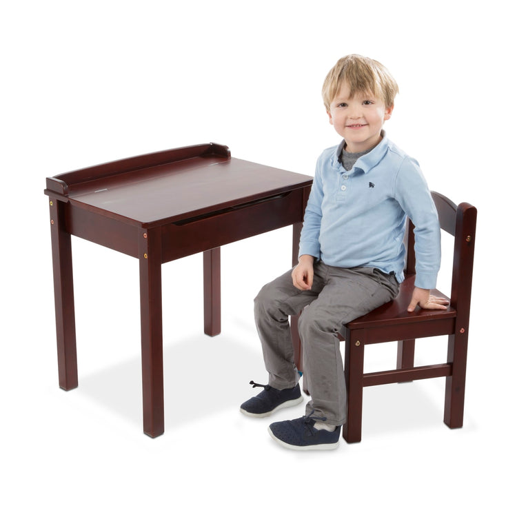 A child on white background with the Melissa & Doug Wooden Child's Lift-Top Desk & Chair - Espresso
