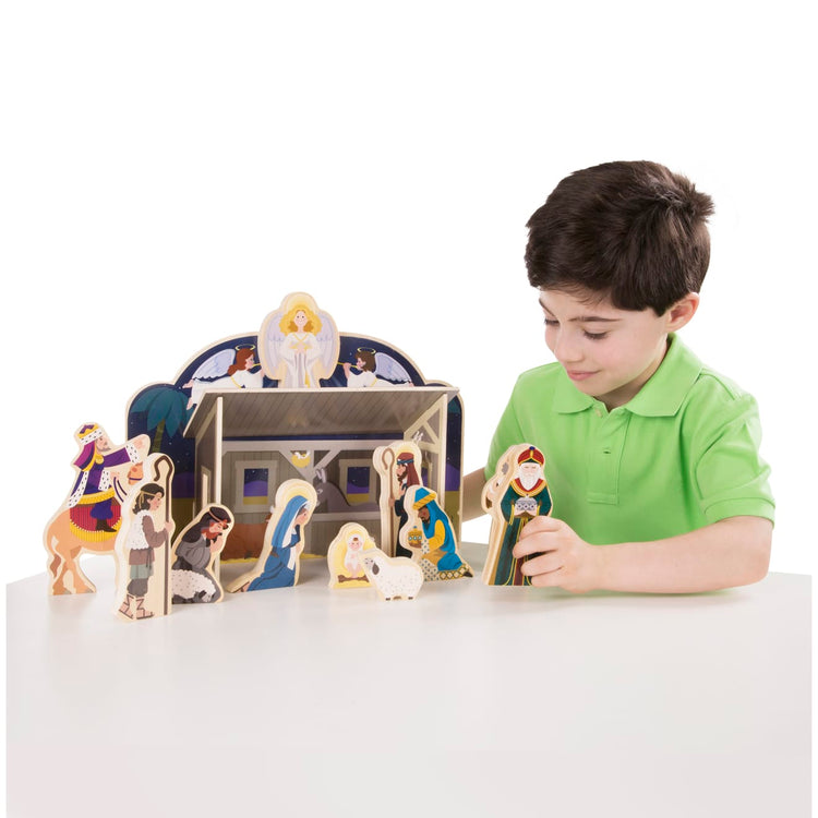 A child on white background with the Melissa & Doug Classic Wooden Christmas Nativity Set With 4-Piece Stable and 11 Wooden Figures