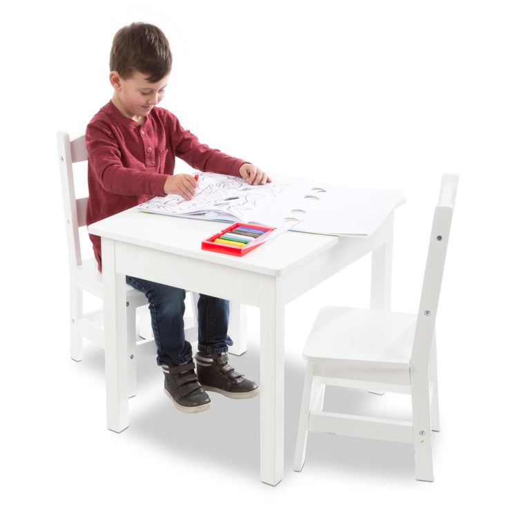 A child on white background with the Melissa & Doug Wooden Kids Table and 2 Chairs Set - White Furniture for Playroom