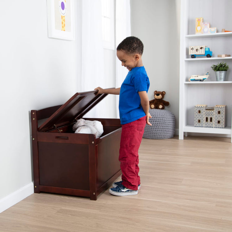 A kid playing with the Melissa & Doug Wooden Toy Chest (Espresso)