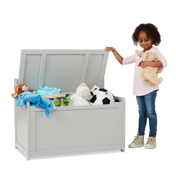 A child on white background with the Melissa & Doug Wooden Toy Chest (Gray)