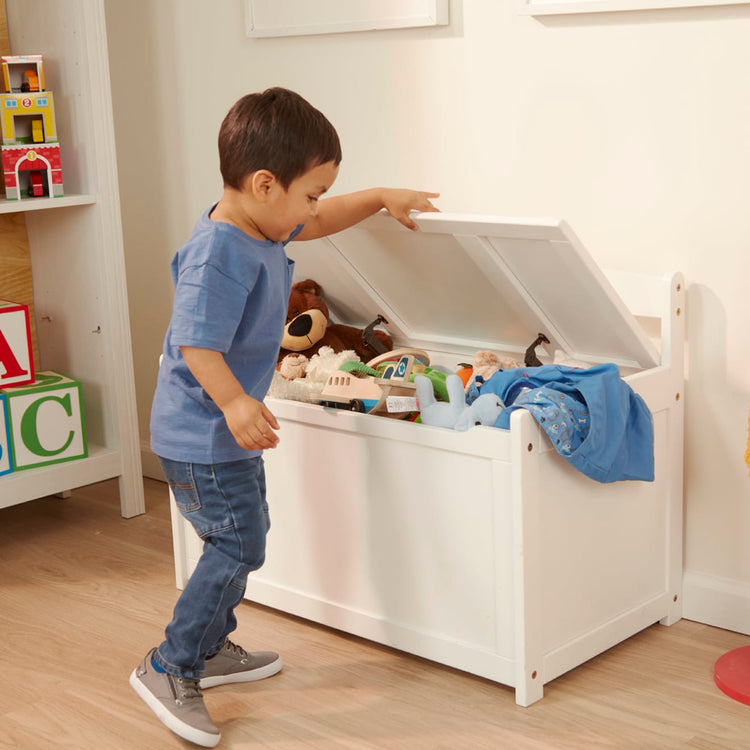A kid playing with the Melissa & Doug Wooden Toy Chest (White)