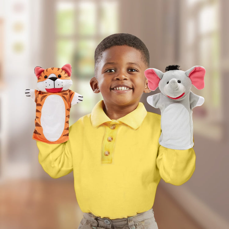 A kid playing with the Melissa & Doug Zoo Friends Hand Puppets (Set of 4) - Elephant, Giraffe, Tiger, and Monkey